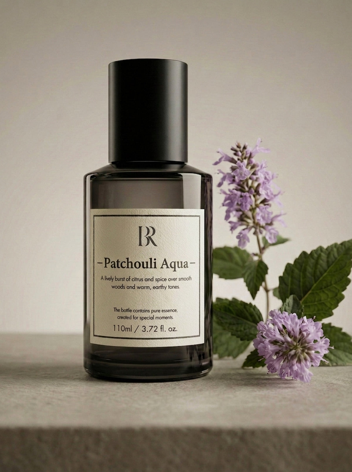Esență de parfum ambiental Barrano Patchouli Aqua 110ml — flacon pe fundal neutru cu flori de mentă